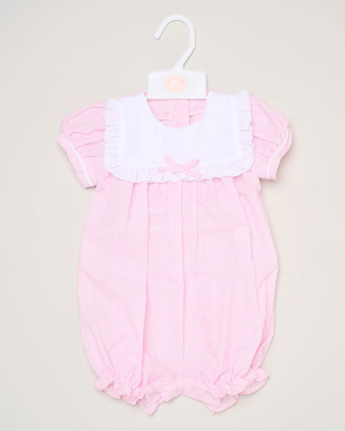 The Baby Girls Smocked Romper features pink and white stripes, short puff sleeves, a white ruffled collar, and a small front bow. It is shown on a white hanger against a plain background.